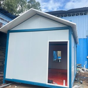 Exterior view of finished modular container building with thermal sandwich panels and blue steel trim.