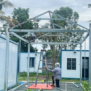 ESSP technical team assembling and welding pitched roof structural steel trusses in the workshop yard.