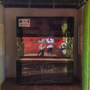Protective-wrapped commercial drinking water dispensing unit installed inside school shelter.